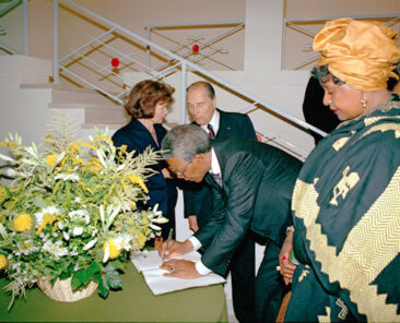 Mandela signe le livre d'or de la fondation France Libertés.
Au fond, Danièle et François Mitterrand